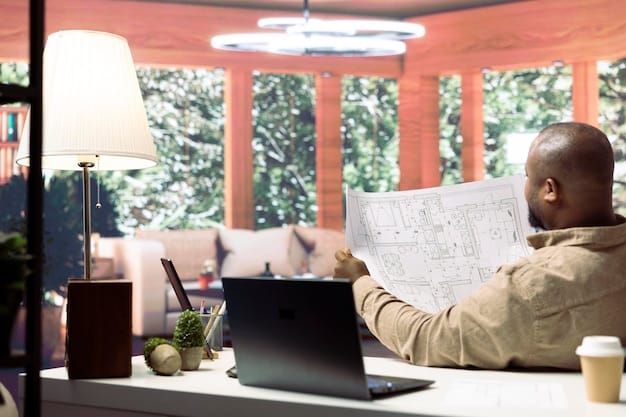 A person analyzing data and charts on a laptop, with a real estate brochure visible in the background. The setting is a modern home office with natural light.