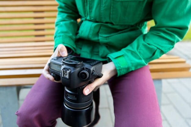 A close-up shot of a photographer reviewing images on a professional camera in a brightly lit studio, with various lenses and photography equipment visible in the background, symbolizing the technical aspects of creating high-quality stock photos.