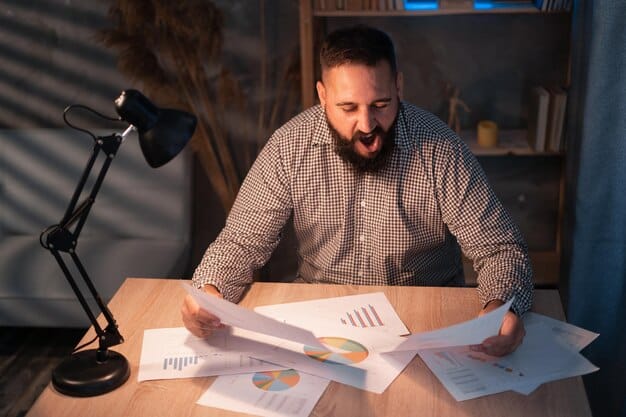 A person sitting at a desk, reviewing financial documents and using a calculator, emphasizing the importance of analyzing one's financial situation before setting goals.